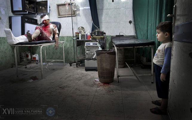 Un niño en el hospital Dar Al-Shifa mira a los pacientes heridos. El hombre herido fue llevado junto a su esposa, embarazada, al hospital. Ambos están en estado crítico. / Niclas Hammarström